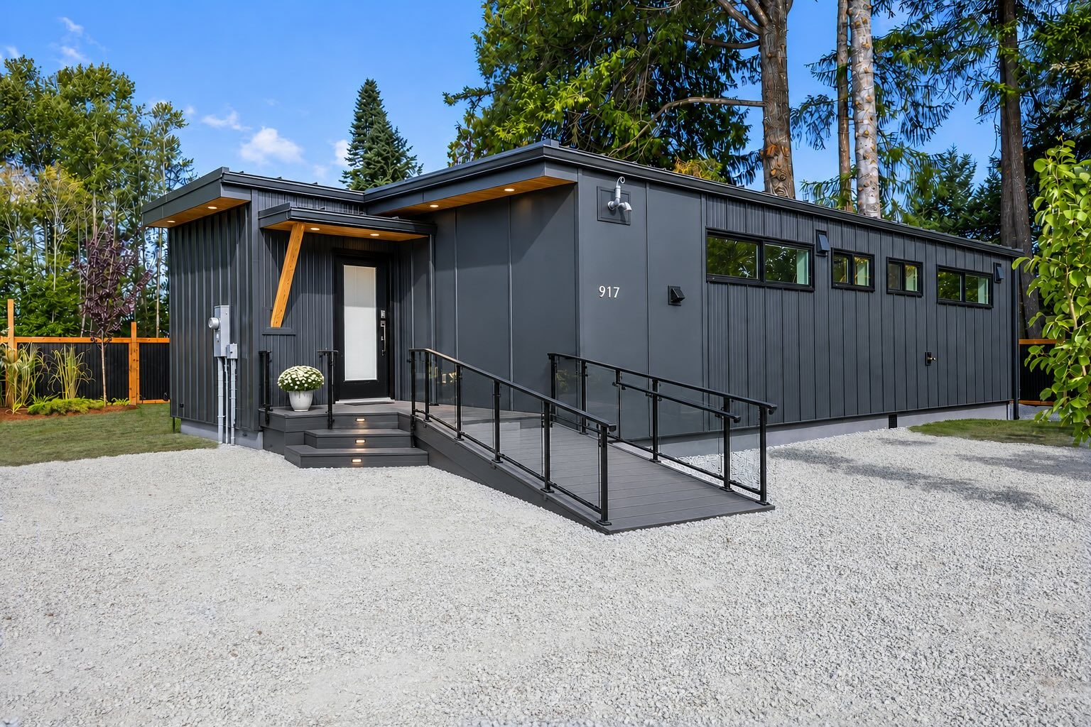 A single-level accessible home with a step-free ramped entry, set against an evergreen forest